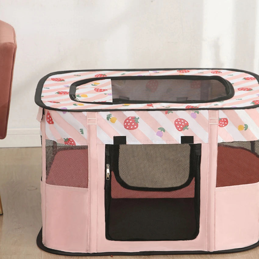 Pink pet playpen with strawberry pattern on a light wooden floor.