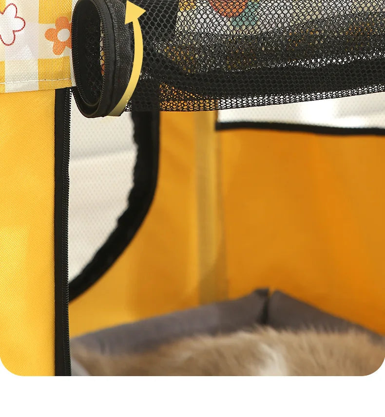 Close-up of a yellow tent with a black mesh door and floral patterned fabric.