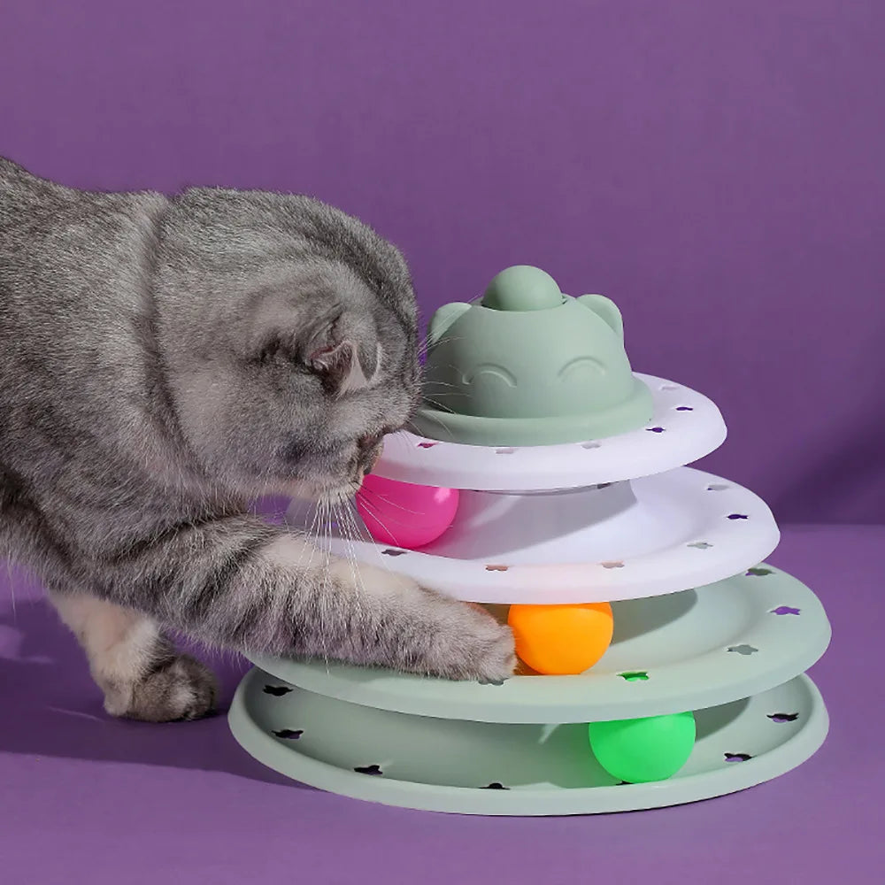 Cat playing with a colorful tiered cat toy on a purple background