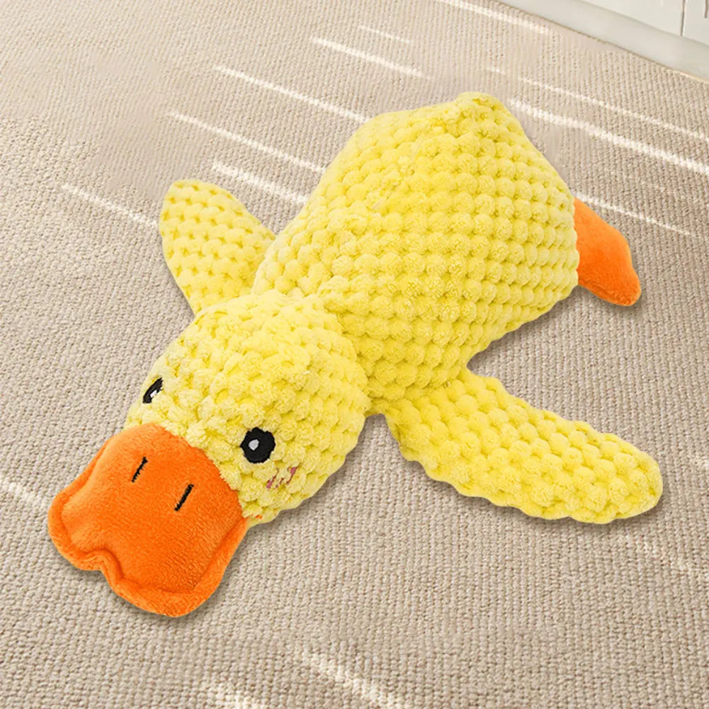 Yellow duck toy with an orange beak on a beige carpet