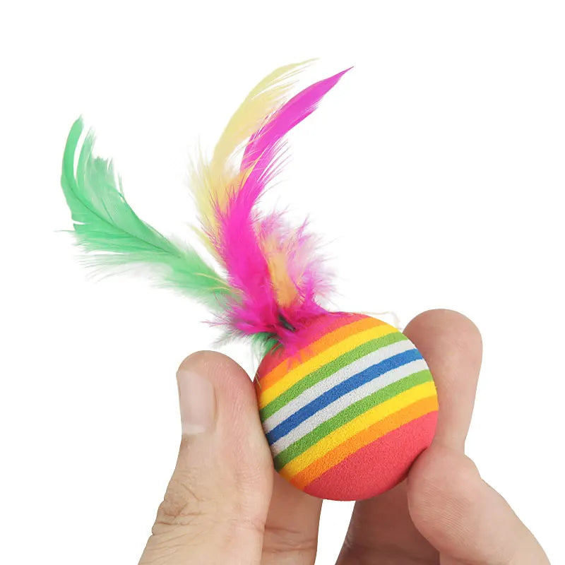 Colorful striped ball with feathers held in a hand on a white background