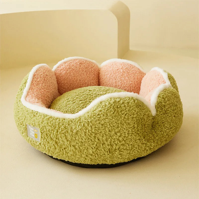 Green pet bed with pink interior on a beige background