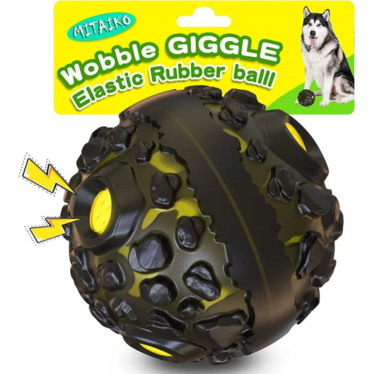 Black and yellow wobble giggle elastic rubber ball toy for dogs with packaging in the background.