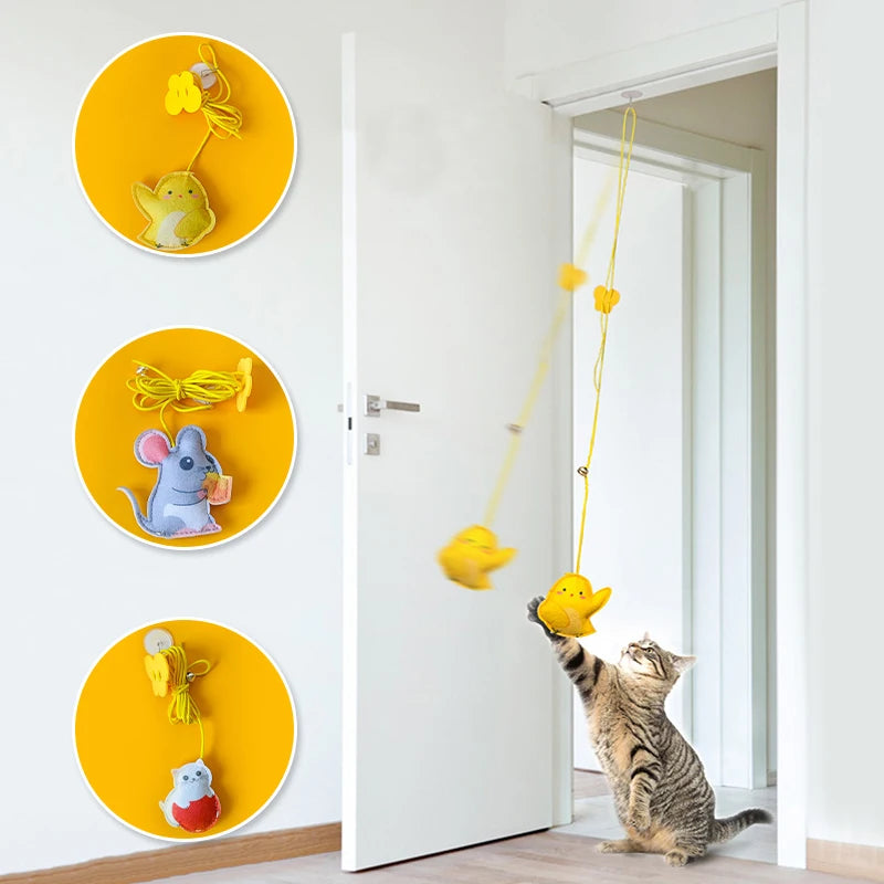 Cat playing with a yellow hanging toy attached to a door frame, with additional toys on yellow circular holders on the wall.