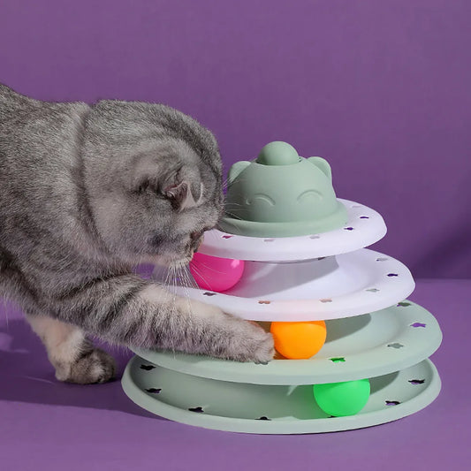 Cat playing with a colorful tiered cat toy on a purple background